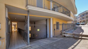 A multi-story residential building with balconies, a gated entrance, and a paved sidewalk. - 4065 Kalès Holiday by Barbarhouse (Otranto)