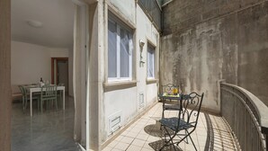 A small balcony with a table and chairs, a view of the building's interior, and a door leading to another room. - 4065 Kalès Holiday by Barbarhouse (Otranto)