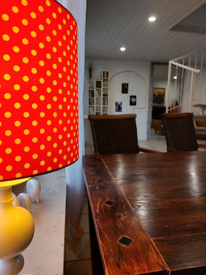 Ein Holztisch mit einer roten Tischlampe mit weißen Punkten.