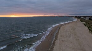 Escena de playa costera con una extensa playa arenosa y el océano.