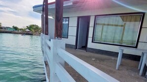 A waterfront building with a white exterior, large windows, and a covered outdoor area. - The Beach Park hadsan by Hiverooms (Lapu-Lapu)
