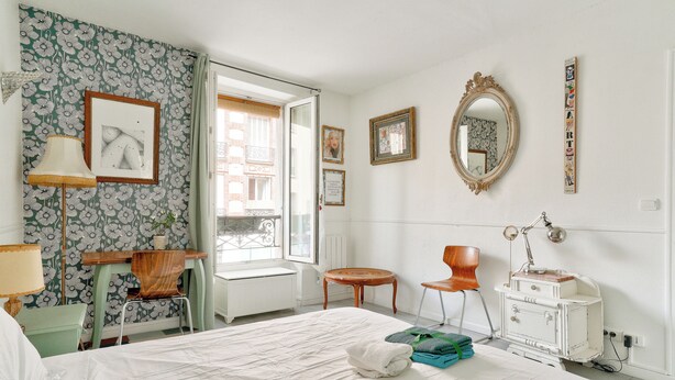 Un dormitorio con cama, escritorio, silla, cómoda y espejo.