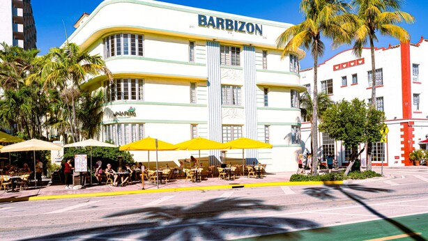Een BarBizon hotel met terras en palmbomen.