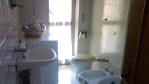 Ein Badezimmer mit Waschbecken, Bidet, Toilette und Badewanne.