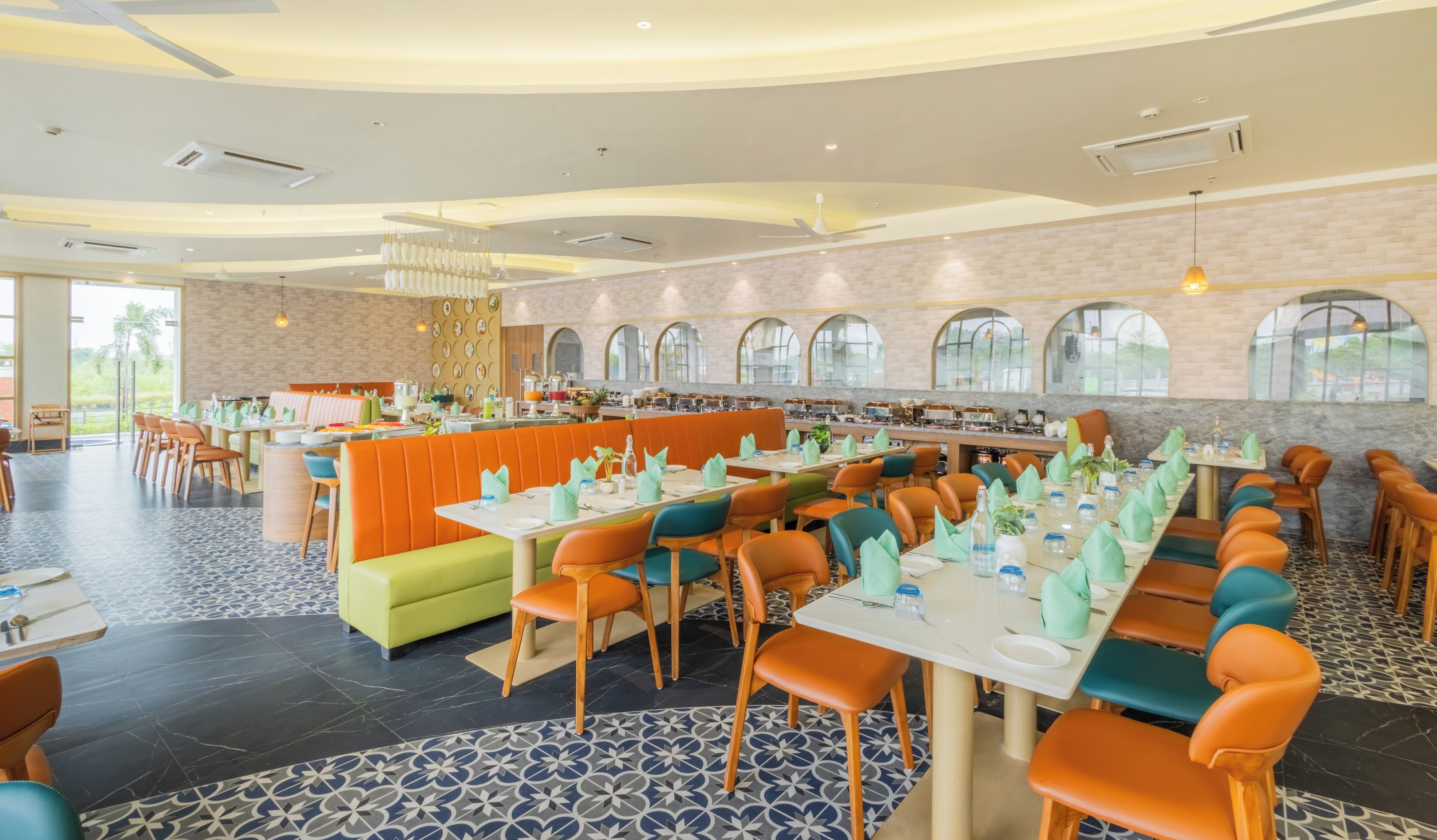 Un vaste espace dédié à la salle à manger, avec de nombreuses tables et des banquettes, et un aménagement moderne qui propose différents types de sièges.