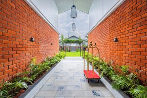 A corridor with brick walls, a red carpet, and a swing chair.