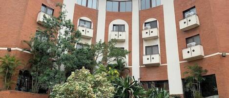 A multi-story building with a curved facade, featuring balconies on each floor.