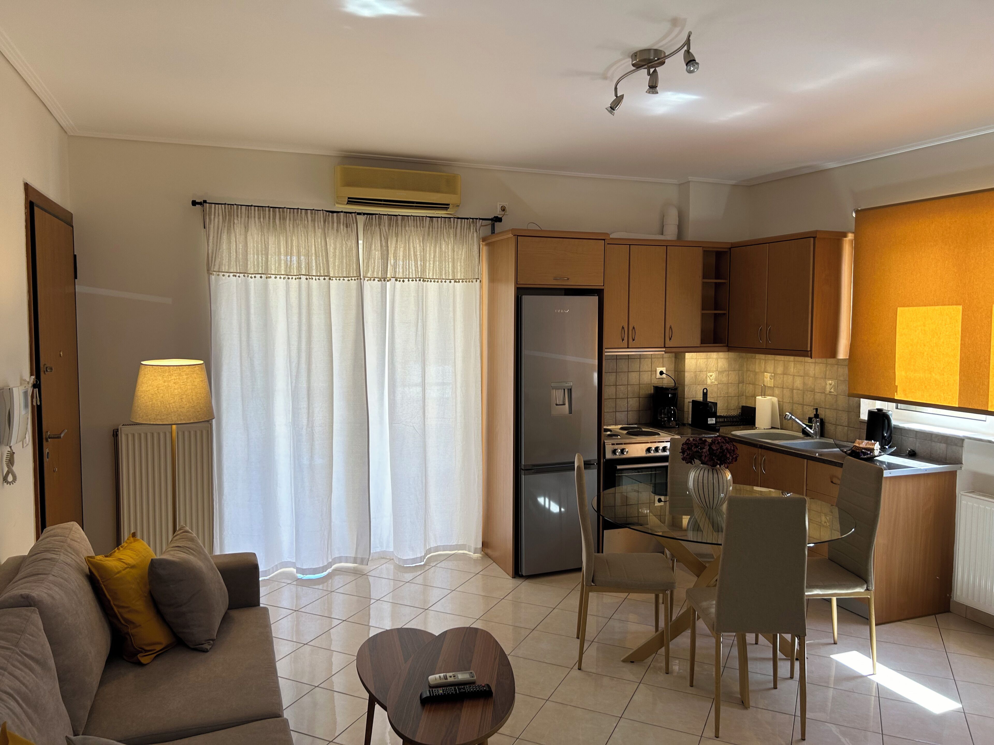 A modern kitchen with a refrigerator, stove, and dining area.