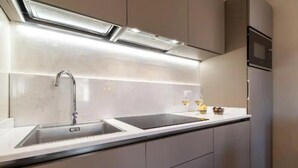 Eine moderne Küche mit doppelter Spüle, Armatur aus Edelstahl und einem eingebauten Backofen.