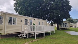A mobile home with a covered porch and a small deck. - D&ashortbreaks-stmargaretsbay-parking (Dover)