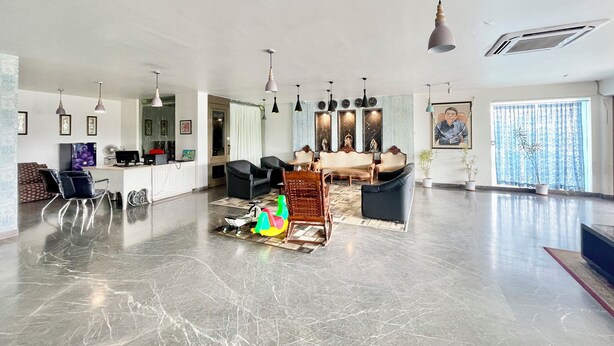 A spacious living area with a marble floor, a sofa set, a dining table, and a kitchen area with a refrigerator and a sink. - Hotel V-i sea view - Puri  (Puri)