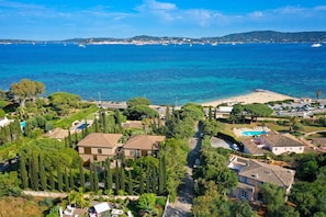 Una zona residencial costera con casas, una playa y una vista despejada del mar.