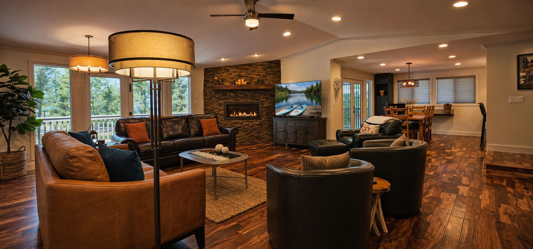 Un salon spacieux doté d’une cheminée, de canapés en cuir, d’un téléviseur et d’un coin repas offrant une vue agréable.