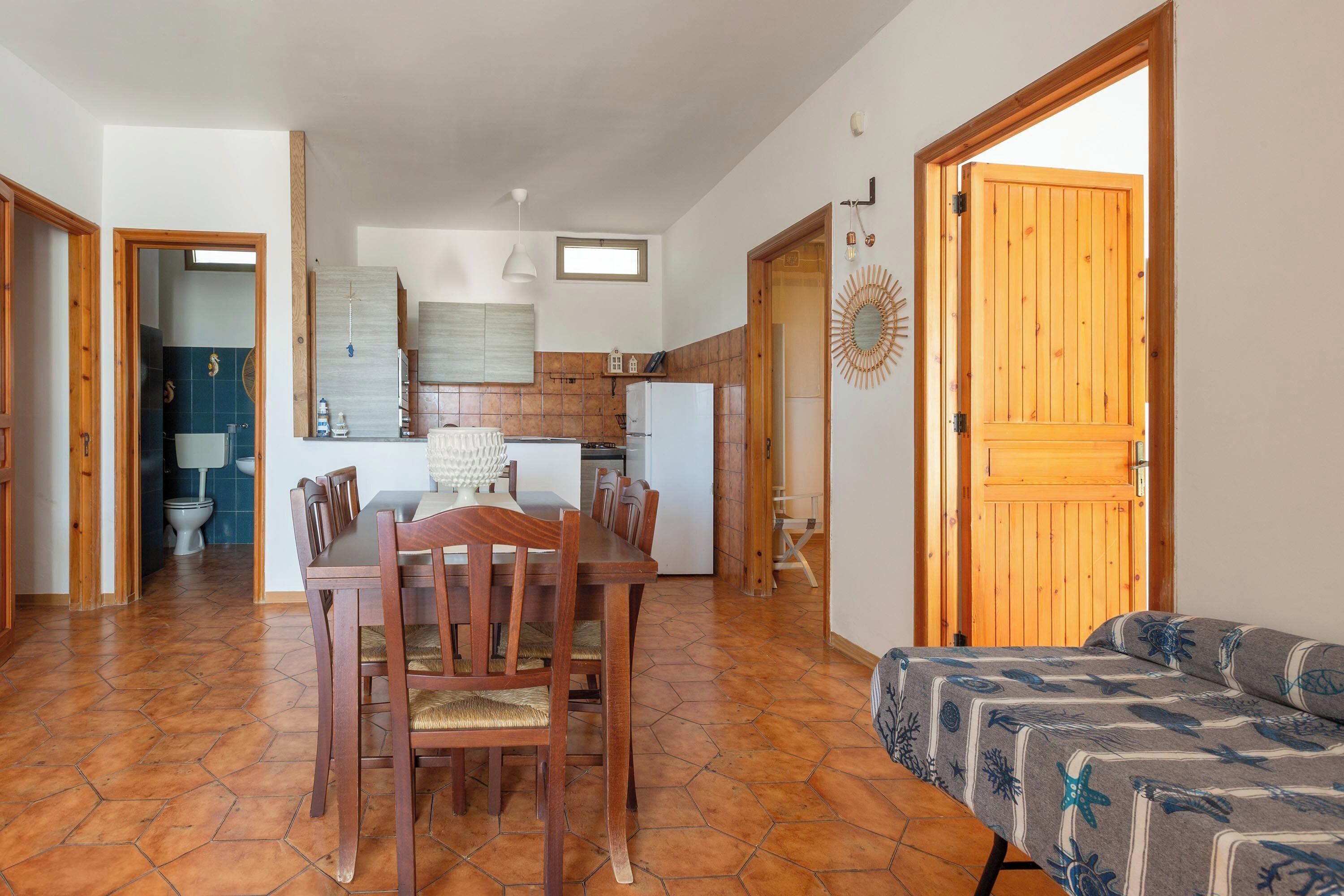 Un espace de vie compact comprenant un coin repas, une kitchenette et un coin salon confortable.