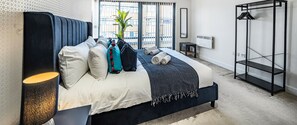 Une chambre moderne avec un lit, une table de chevet et une armoire.