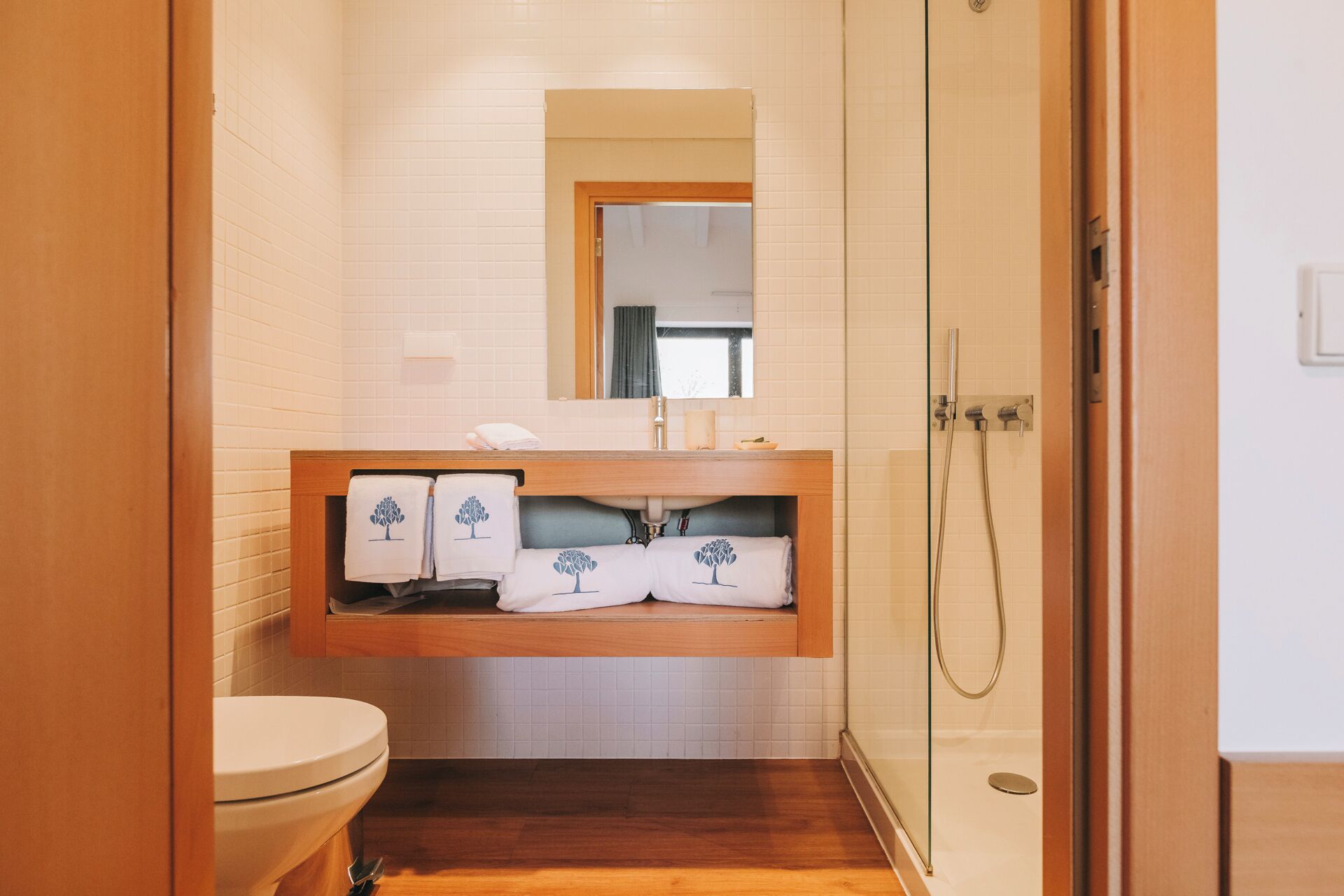 Een badkamer met toilet, wastafel met spiegel en douche.