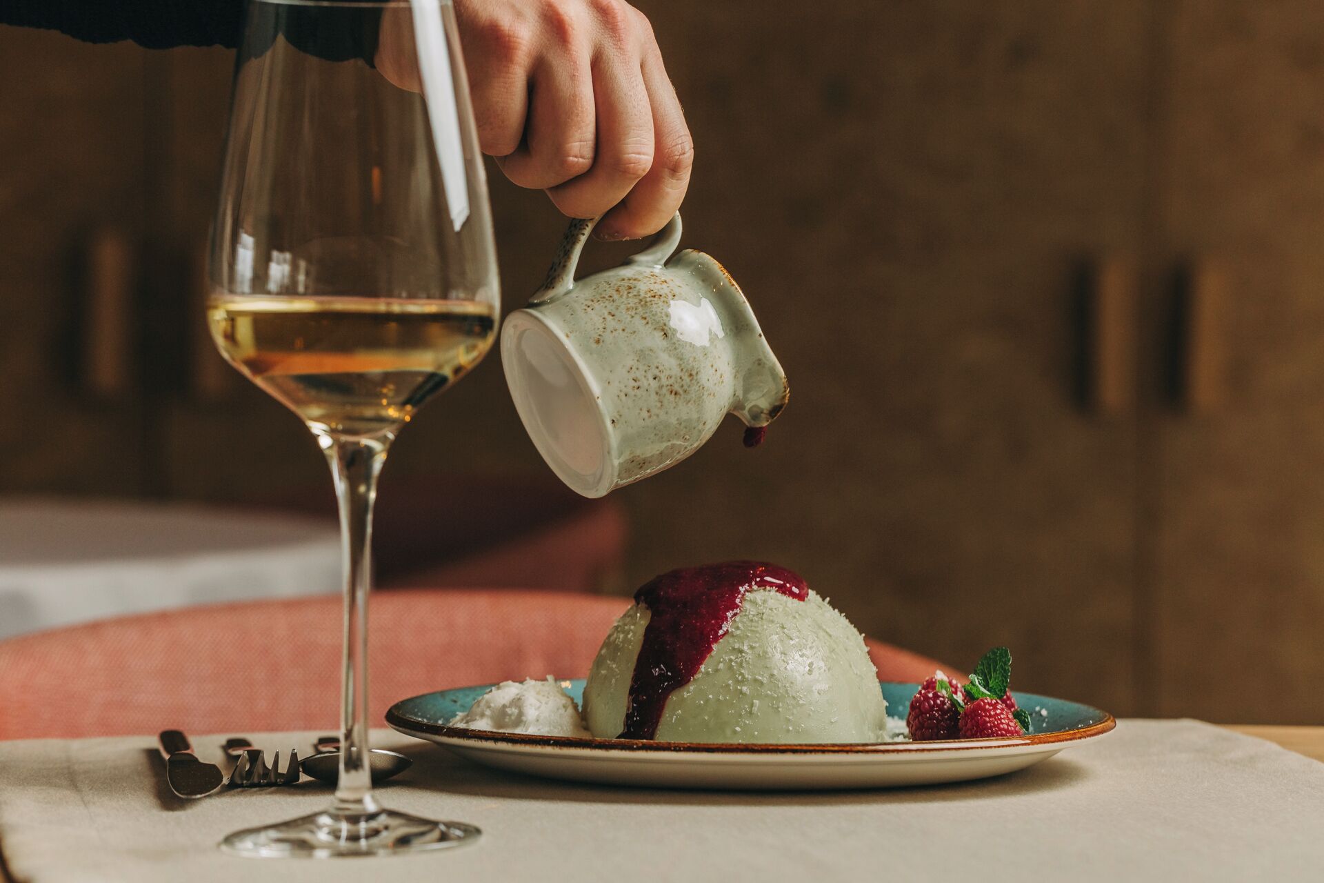 A dessert on a plate with a glass of white wine.