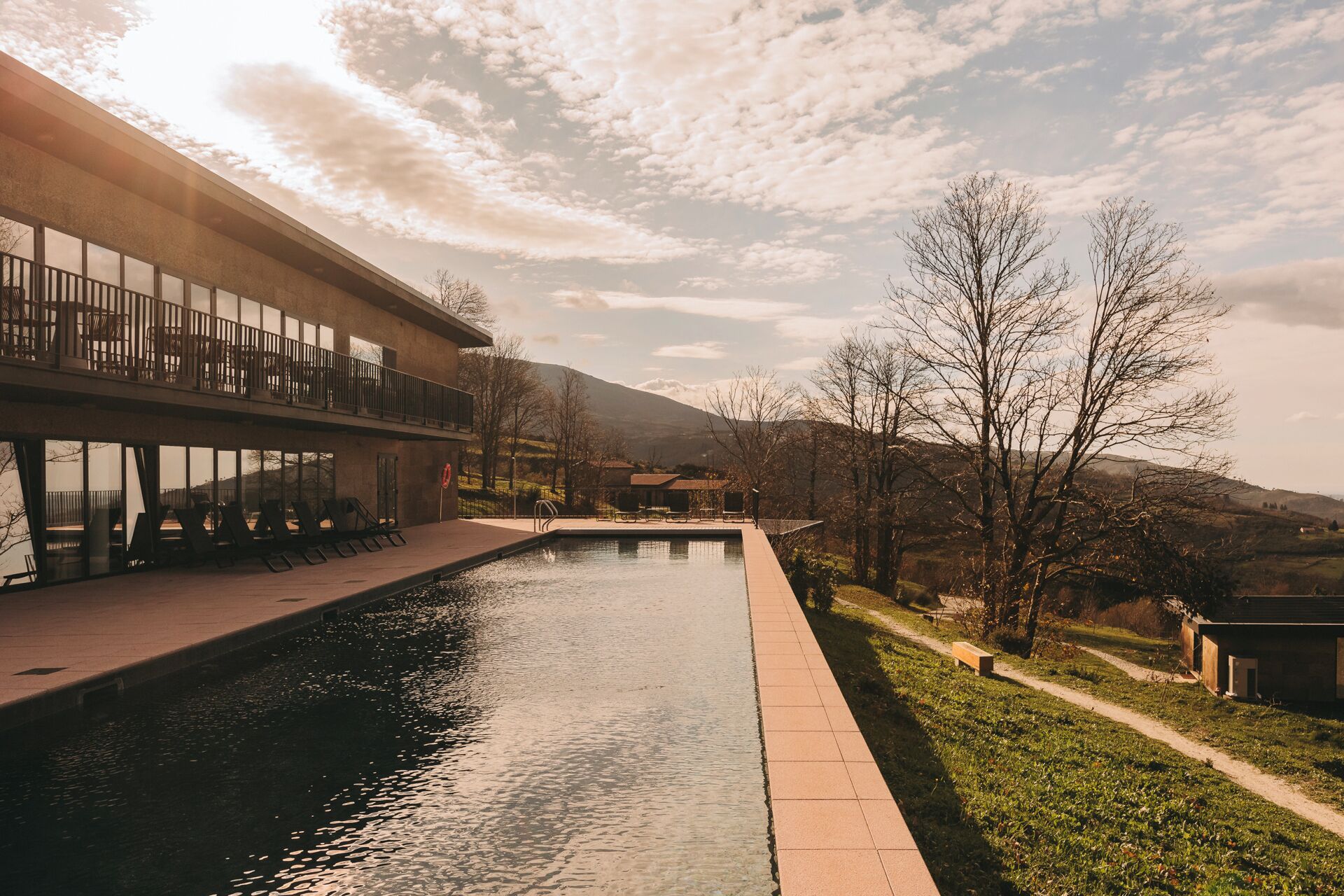 Een buitenzwembad, parasols bij het zwembad en ligstoelen