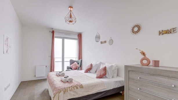 A bedroom with a bed, a dresser, a window with curtains, and wall decorations.