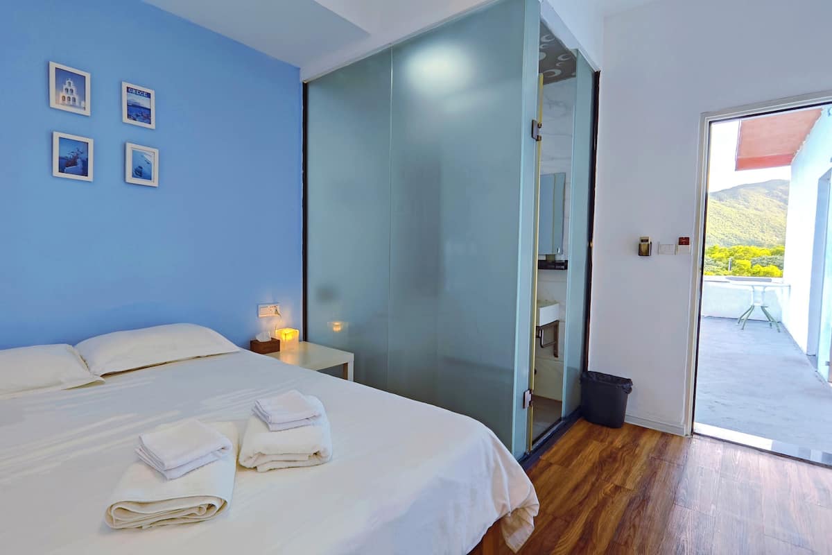 Une chambre à coucher avec un lit, une table de chevet et un mur orné de tableaux.