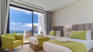 A hotel room with two beds, a sofa, and a large window with a view of the ocean. - Luxury Diamond House (Funchal)