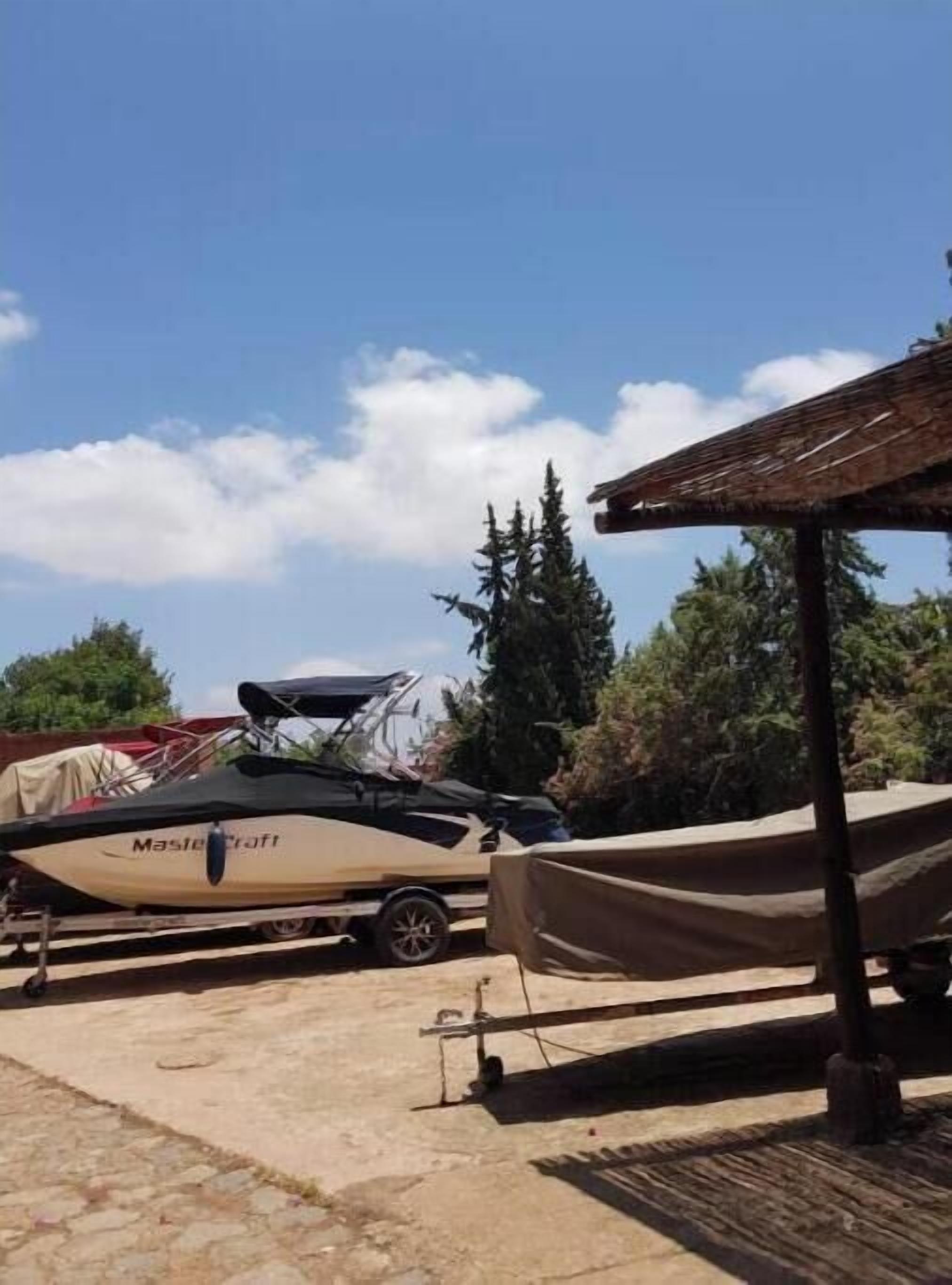 A boat named 'Mastercraft' parked on a dock with a covered area nearby.