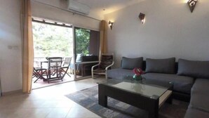 Una sala de estar con sofá, mesa de centro y comedor con sillas y una mesa.