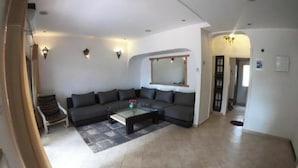 Una sala de estar con un sofá, una mesa de centro y un espejo en la pared.