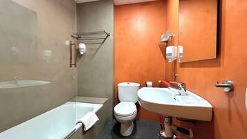 A modern bathroom with a bathtub, toilet, and sink.