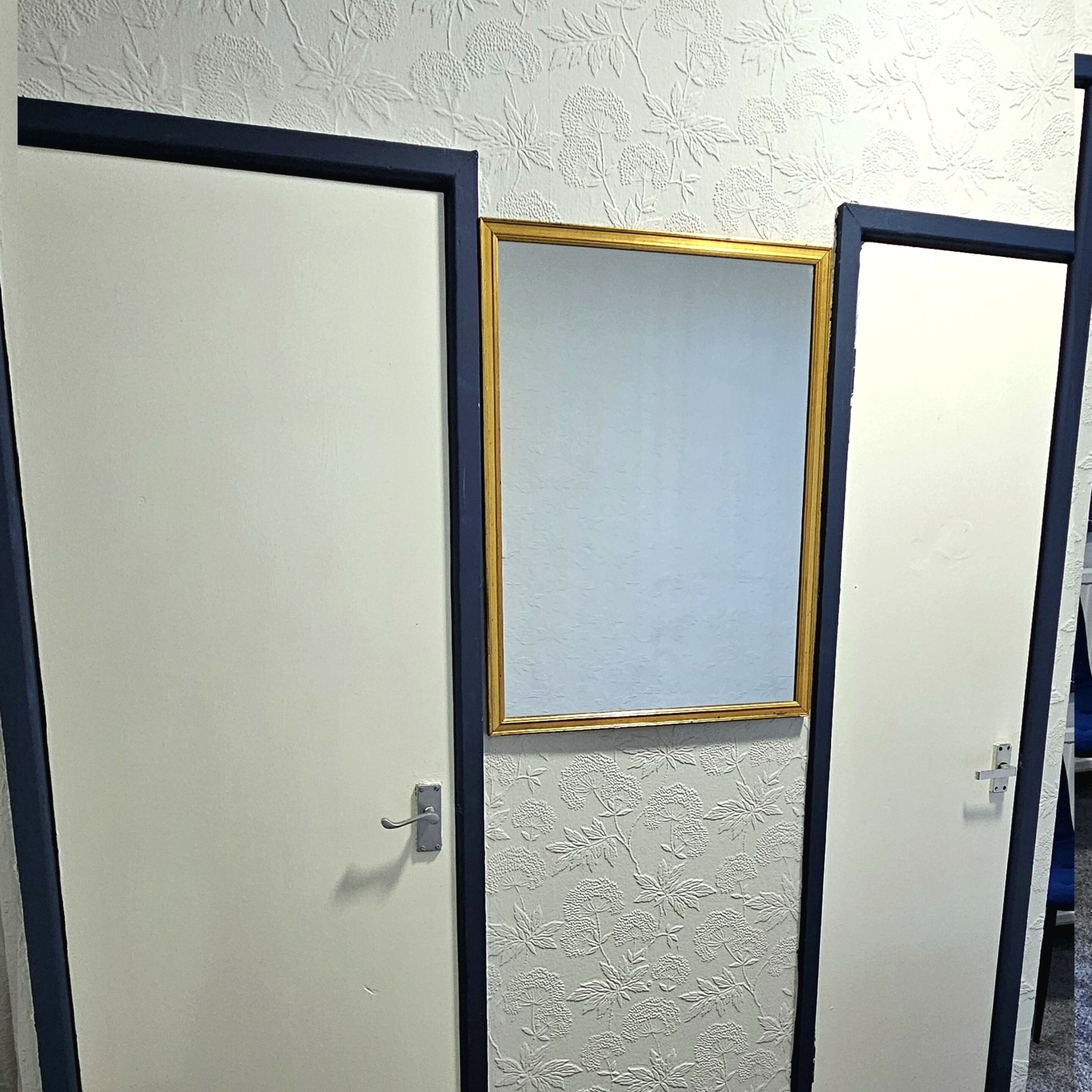 Une pièce dotée de deux portes, l’une avec un cadre doré et l’autre sans ornement.