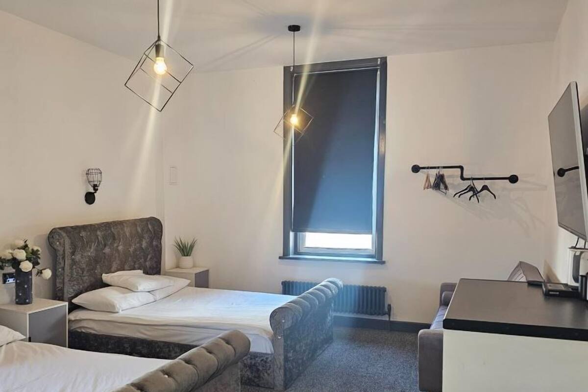 Una habitación de hotel moderna con cama, sofá, escritorio y ventana.