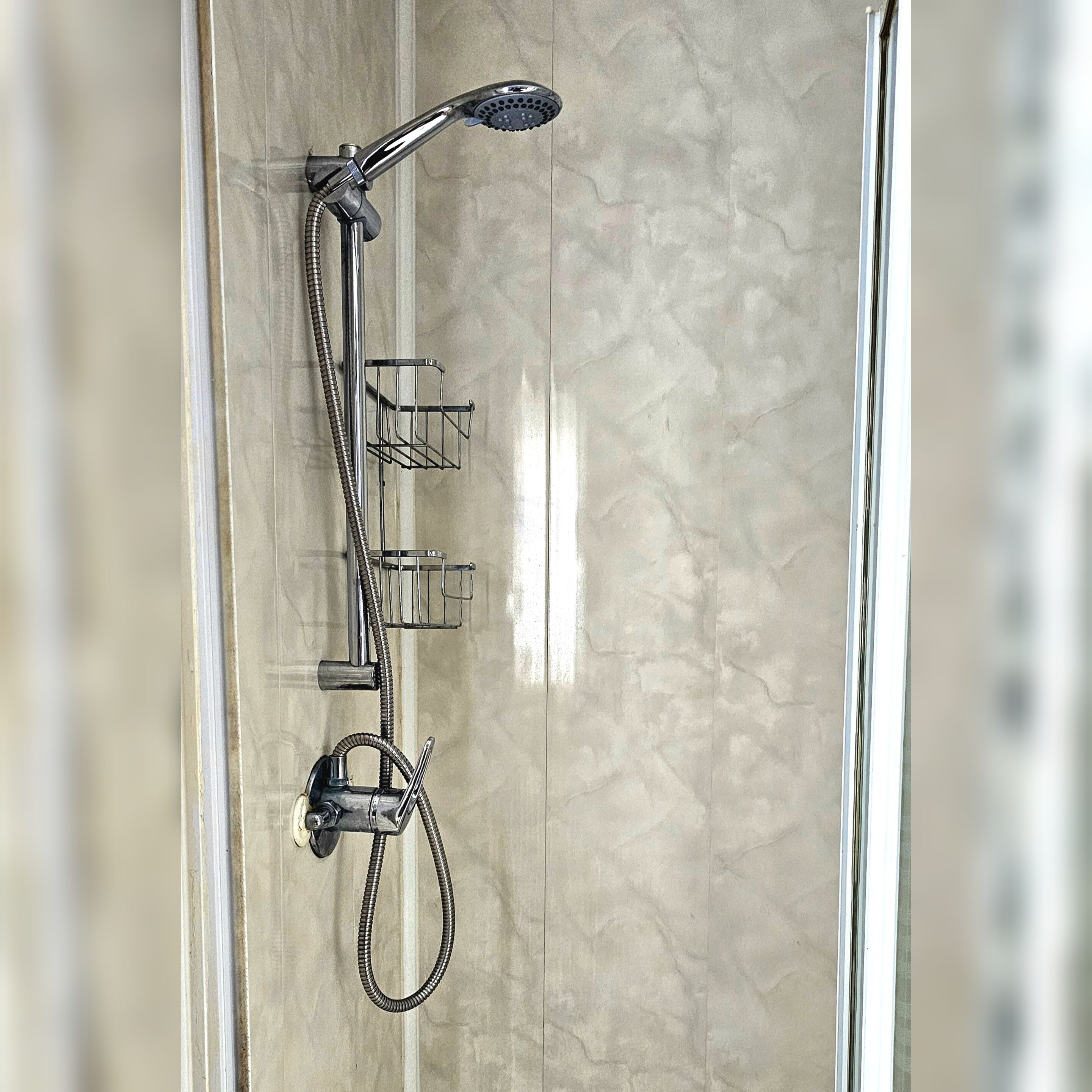 A bathroom with a shower, a towel rack, and a toilet.