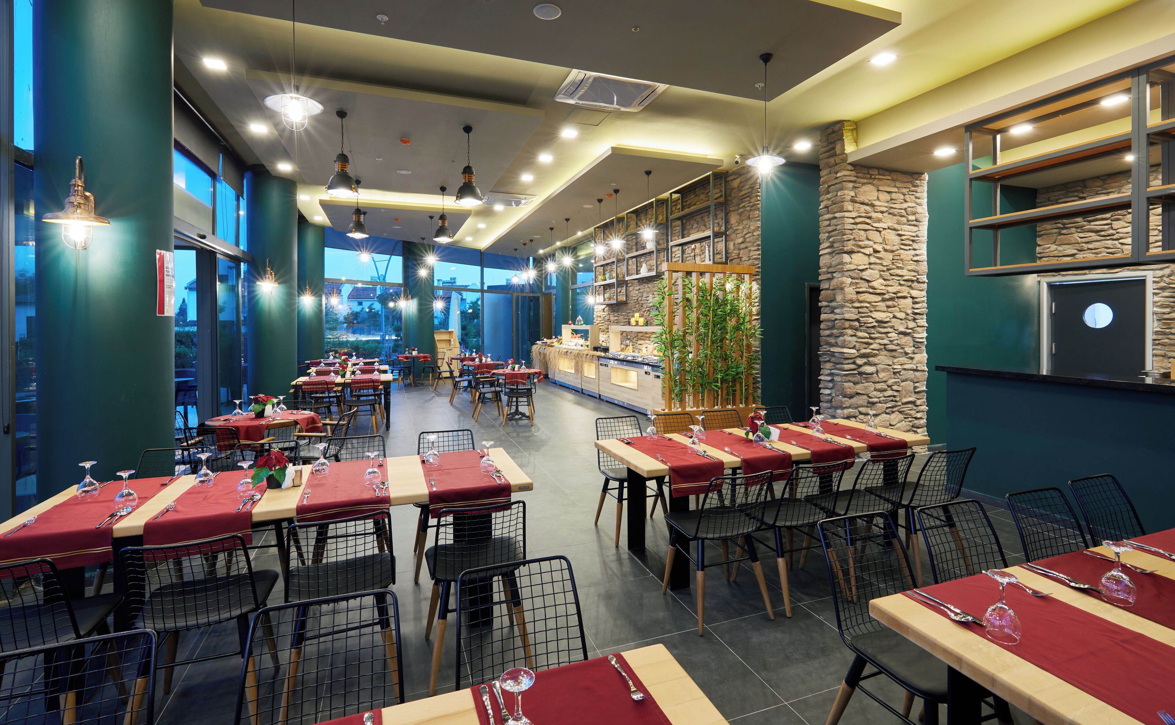 Un restaurant avec plusieurs tables, des chaises et un mur en pierre.