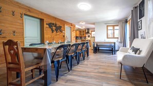 Zona pranzo con pareti in legno, un tavolo lungo e sedie.