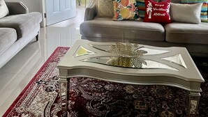 A living room with a sofa, a coffee table, and a patterned rug. - Royal Vacation Retreat (Falmouth)