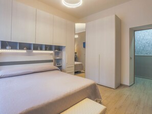 Une chambre à coucher moderne avec un lit, des étagères intégrées et une armoire.
