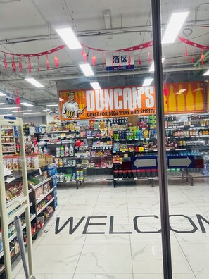 A store interior with shelves stocked with various products, a prominent 'DUNCAN'S' sign, and a 'WELCOME' mat.