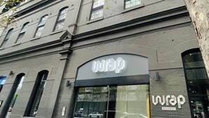 A building with a 'wrap' sign, indicating a commercial space.