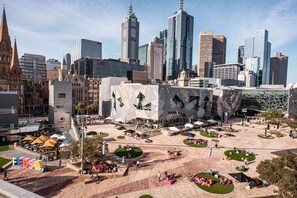 A city square with modern buildings, a historic church, and a unique architectural structure.