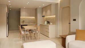 Une cuisine moderne avec des meubles en bois, un coin repas comprenant une table et des chaises, et un petit espace détente avec un canapé et un pouf.