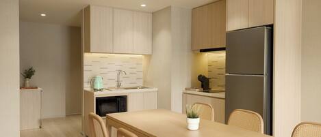 A modern kitchen with wooden cabinets, a stainless steel refrigerator, and a dining area with a table and chairs.