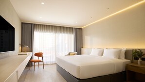 Une chambre d’hôtel moderne, dotée d’un grand lit, d’un bureau et d’une chaise.
