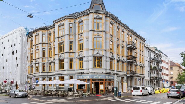 Un immeuble d’angle dont le rez-de-chaussée abrite un restaurant appelé « Villa Paradiso ».