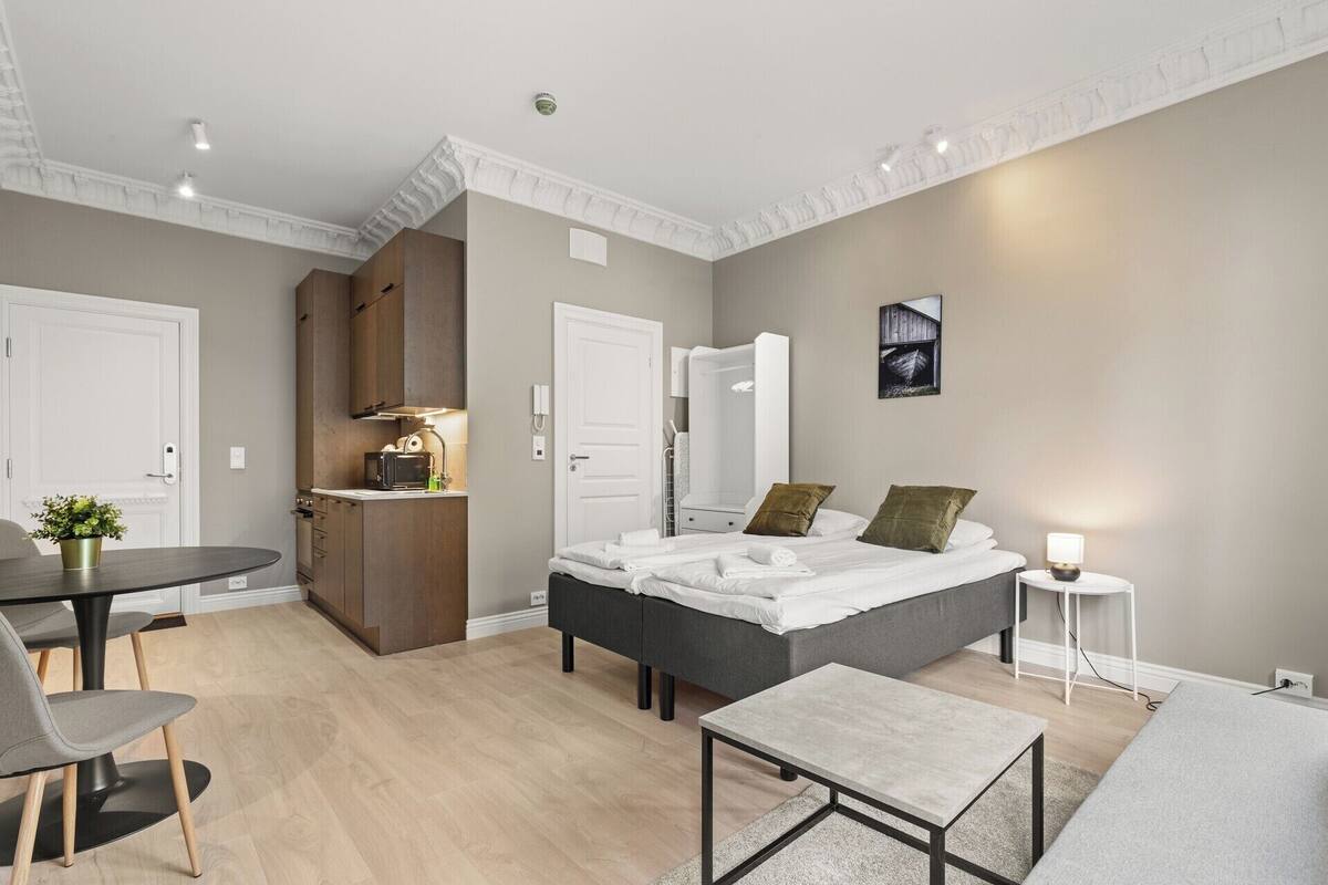 Une chambre à coucher moderne avec un lit, une table de chevet et un petit espace bureau.