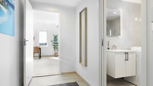 Une chambre d’hôtel moderne avec un grand miroir, une armoire blanche et une vue sur la salle à manger.