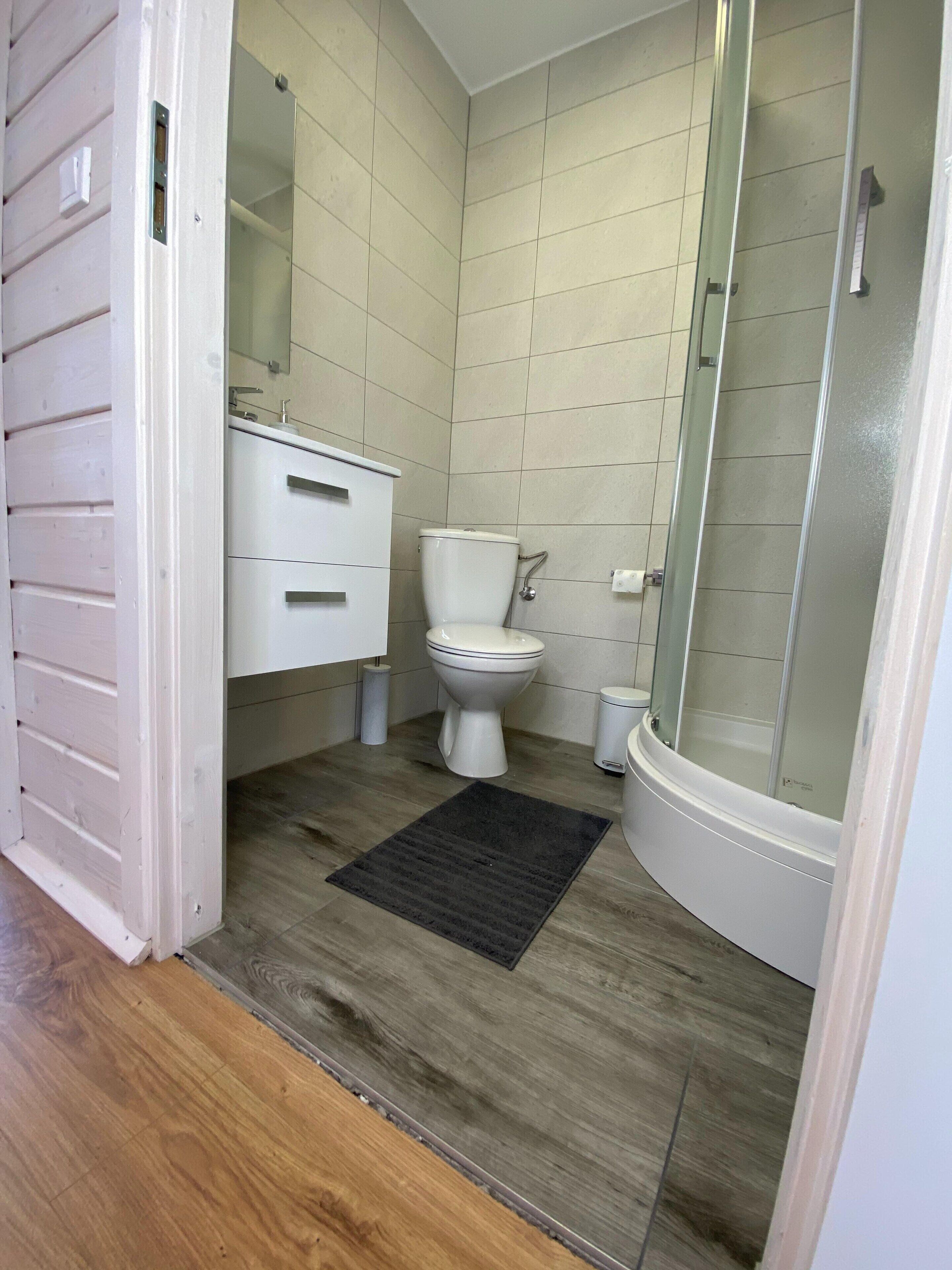 A bathroom with a toilet, sink, and shower.
