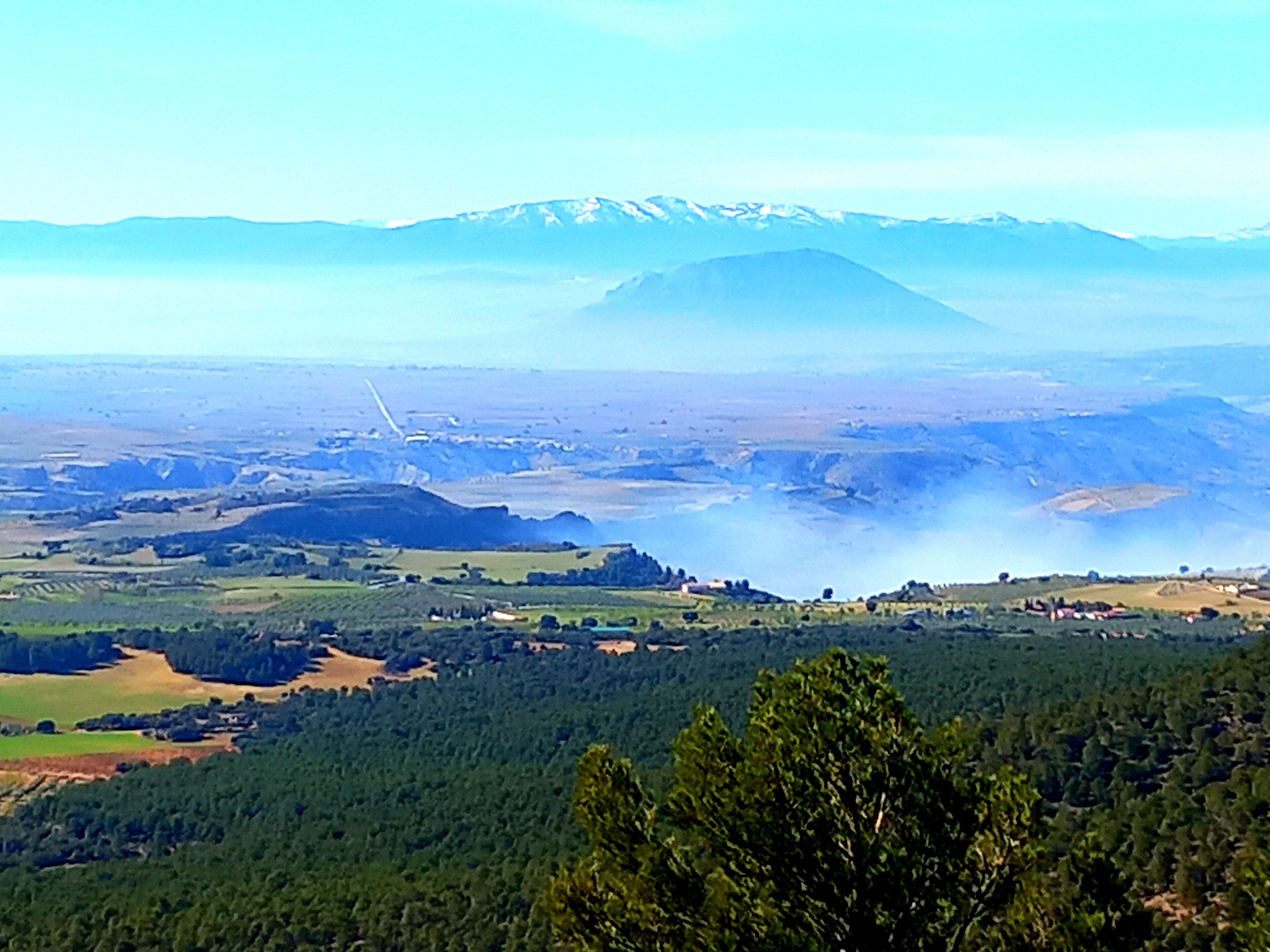 Een panoramisch uitzicht op een berglandschap met een stad in de vallei.