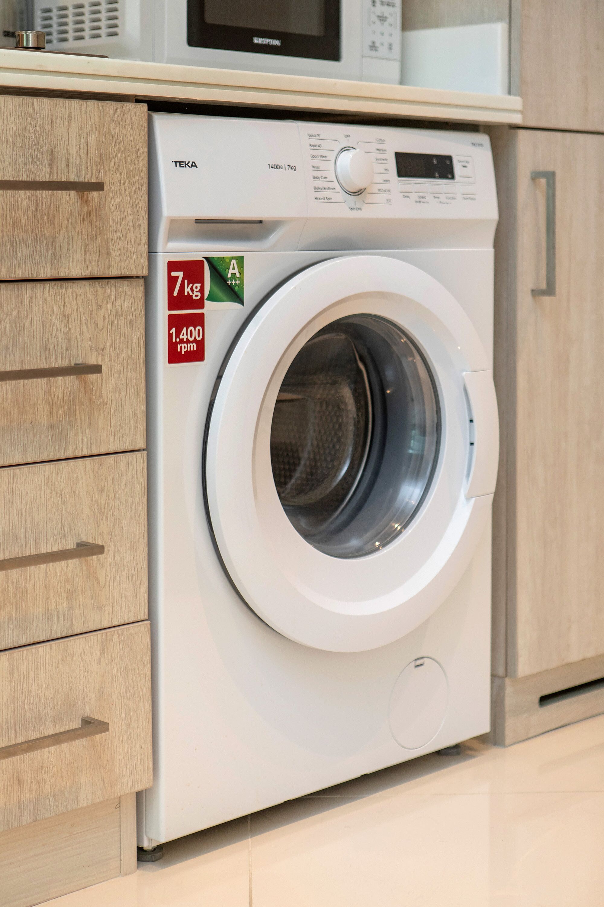 A front-loading washing machine with a digital display, a 7 kg capacity, and 1400 rpm.