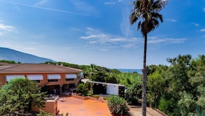 A hotel with a terrace, palm trees, and a view of the sea. - Residence Baia Verde, Valledoria (Valledoria)