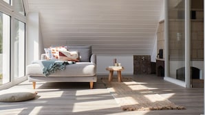 Ein gemütliches Wohnzimmer mit einer Couch, einem kleinen Holztisch und einem Kamin.